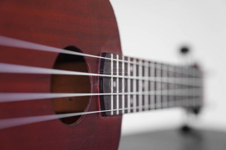 Four stringed ukulele guitar made of wood on a white background. Focus selected