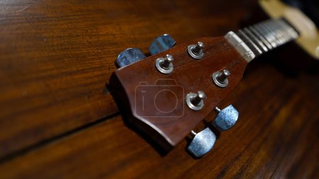 Téléchargez les photos : Four stringed ukulele guitar made of wood on a wooden table. Focus selected - en image libre de droit