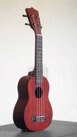 Téléchargez les photos : Four stringed ukulele guitar made of wood on a white background - en image libre de droit