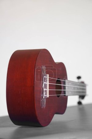 Téléchargez les photos : Four stringed ukulele guitar made of wood on a white background. Focus selected - en image libre de droit