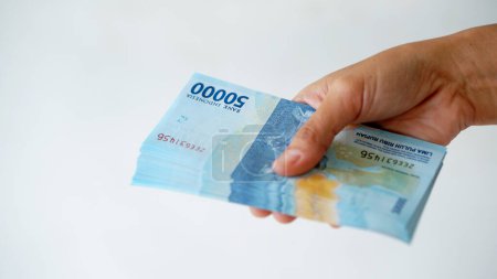 Indonesian rupiah currency, around 50,000 Indonesian money, is held by women's hands