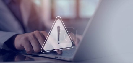 Photo for Businessman uses laptop with warning triangle sign for notification, found error and maintenance concept - Royalty Free Image