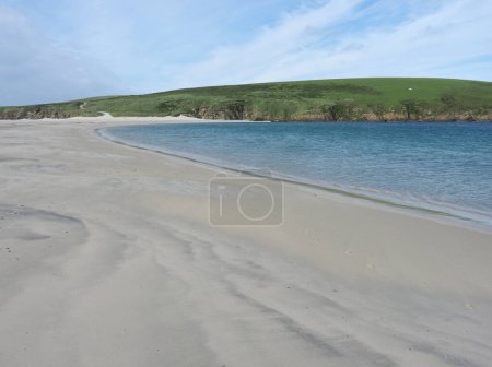 Foto de Playa de St Ninians, un tombolo en las Islas Shetland. St Ninian 's (o St Ninian) Isle es una pequeña isla atada conectada por el tombolo más grande del Reino Unido a la costa suroeste del continente, las islas Shetland, en Escocia.. - Imagen libre de derechos