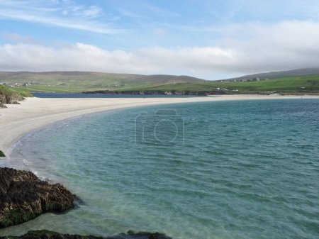 Der Strand von St. Niners, ein Tombolo auf den Shetlandinseln. St. Ninian 's (oder St. Ninian' s) Isle ist eine kleine Insel, die durch den größten Tombolo des Vereinigten Königreichs mit der Südwestküste des Festlandes, den Shetlandinseln in Schottland, verbunden ist..