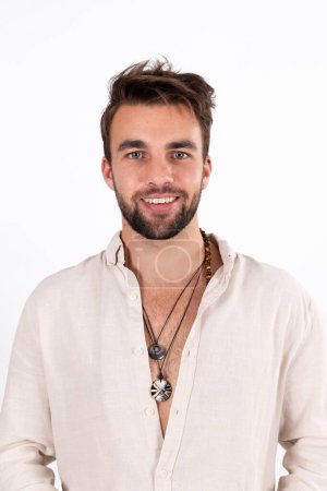 Young handsome bearded man in white shirt against white studio background