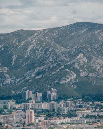 High-rise buildings against rocky mountain backdrop in Marseille