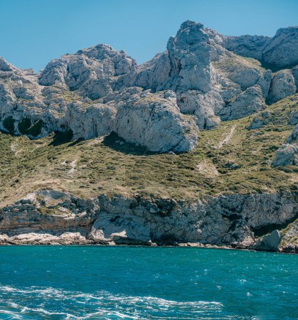 falaises rocheuses escarpées au-dessus d'une mer sereine dans les Calanques, Marseille