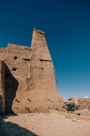 Ancient mud-brick fortress in Siwa Oasis, Egypt under blue sky