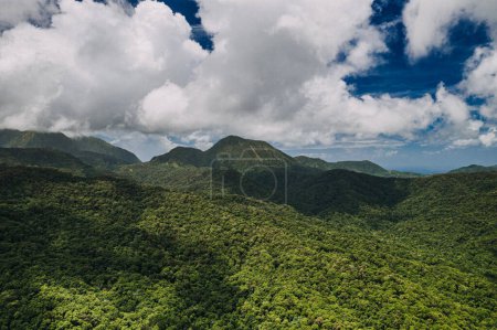Aerial view of lush green mountains under a cloudy sky in Martinique