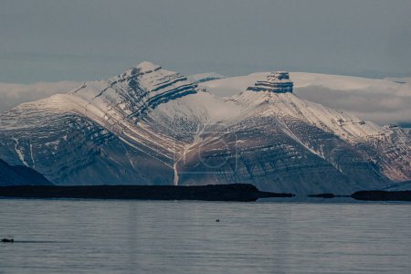Snow-capped mountains with striations at dusk, Longyearbyen, Svalbard