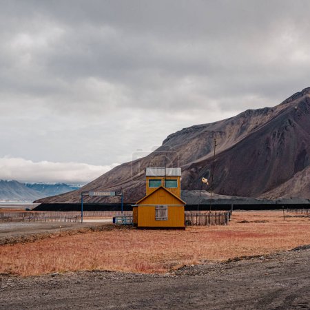 Colorful yellow building in the desolate landscape of Pyramiden, Svalbard