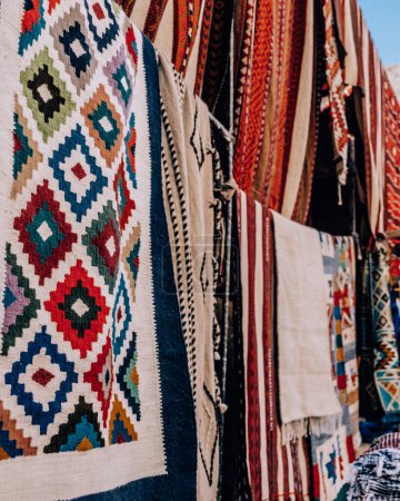 Colorful display of traditional woven rugs at a market in Siwa Oasis, Egypt