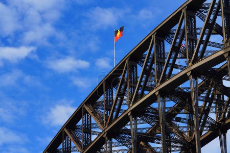 Beau coucher de soleil sur le port de Sydney, drapeau aborigène australien flottant sur le pont du port de Sydney, regardant vers Goat Island et l'entrée de la rivière Parramatta de Walsh Bay