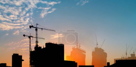 about the tower crane at the building construction in the city when the silhouette