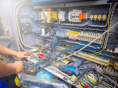 sobre el electricista haciendo reacondicionamiento de sistemas eléctricos hay magnéticos, relé, cable de cableado, interruptor, protección contra sobrecarga, missy