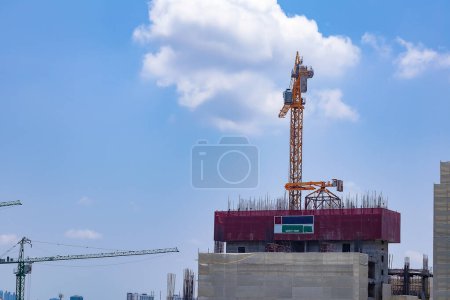 about the tower crane at the construction site and blue sky by emphasizing the tower crane