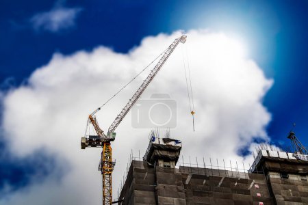 about the tower crane at the construction site and blue sky by emphasizing the tower crane