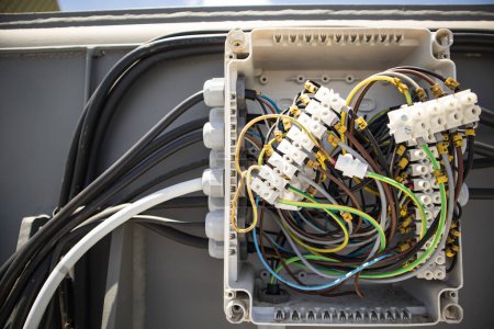 Téléchargez les photos : Sur la boîte de jonction de la machine de panneau électrique et à l'intérieur il y a un enchevêtrement de câble et une borne de câble - en image libre de droit