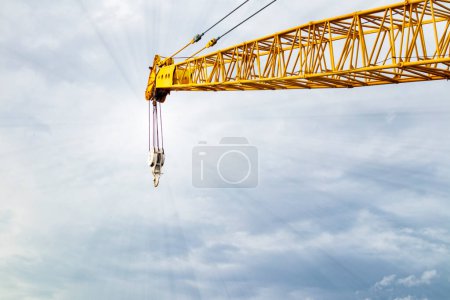 about the boom hoisting of crane at construction site and blue sky by emphasizing at boom crane detail and sling