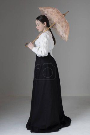 A young Victorian or Edwardian woman wearing a white linen Garibaldi blouse and black skirt 