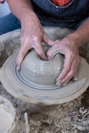 Potter throwing a bowl on a wheel 