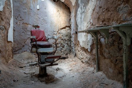 A barber shop chair in a crumbling cell room in the Eastern State Penitentionry of Philadelphia.