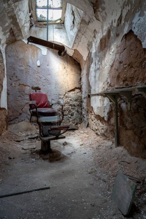 Une chaise de salon de coiffure dans une salle cellulaire en ruine dans la pénitencerie d'État de l'Est de Philadelphie.