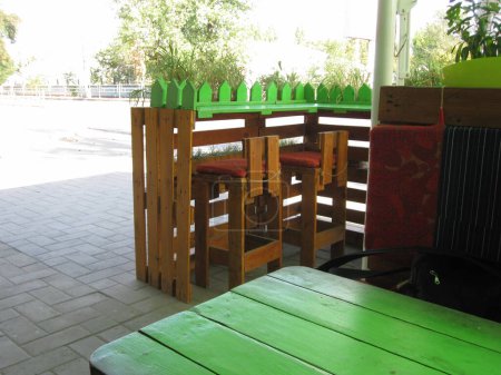 Café de calle en estilo loft, mesa verde con sillas marrones