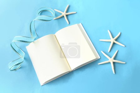 open book and starfish on blue background. heart frame