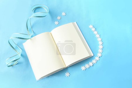 Tarjeta de felicitación navideña. decoración festiva con tarjeta blanca en blanco y árbol de Navidad en azul. plano, vista superior, espacio para copiar.