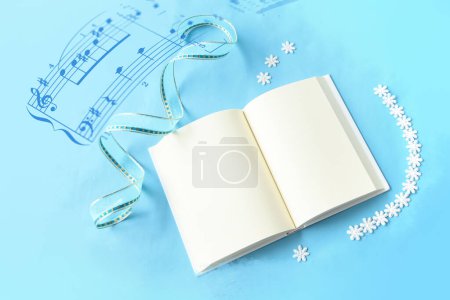 cuaderno abierto con decoración navideña, sobre fondo de color