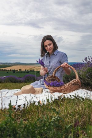 Beautiful Young women in the lavender field. She is rests enjoing.High quality photo