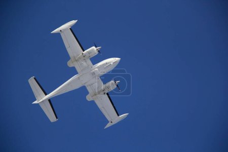 Twin-Engine Aircraft Flying Against Clear Blue Sky