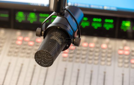 Professionelles Podcasting-Setup: Dynamisches Mikrofon mit verschwommenem Mischpult-Hintergrund im Radiostudio. 