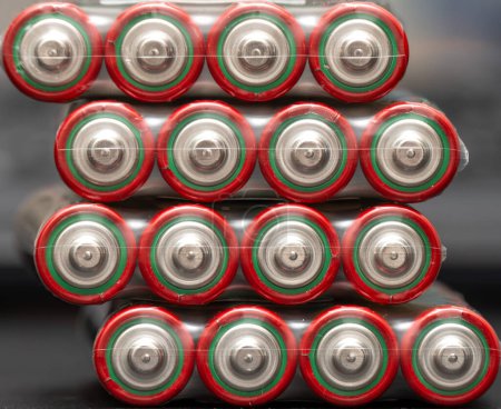Close-up angled view captures several AA batteries stacked neatly, each featuring distinct red and green bands around their silver bodies, suggesting high performance and reliability in electronic devices.