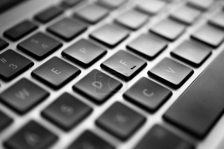 Close-up capture of a modern laptop keyboard with a thematic focus on the letter 'E'. The photo emphasizes the detailed texture and the seamless design of the keys.