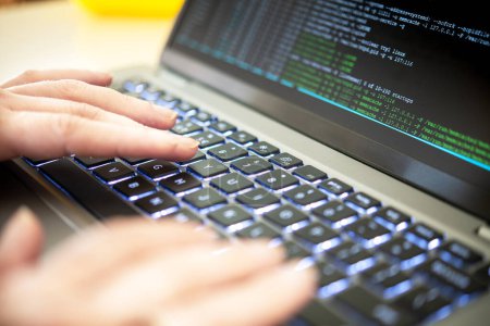 Hacker-Code auf einem Laptop, der Fragen der Cybersicherheit, Bedrohungen der Privatsphäre, Datenlecks und Serverprozesse hervorhebt. Ein Experte für Cybersicherheit identifiziert Schwachstellen und überprüft Virencode und Malware.