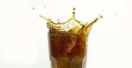 Téléchargez les photos : Glaçons tombant dans un verre de coke sur fond blanc - en image libre de droit