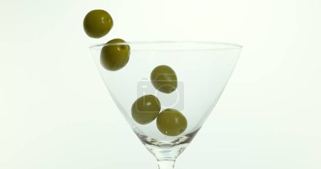 Photo for Olive Falling into a Glass against White Background - Royalty Free Image