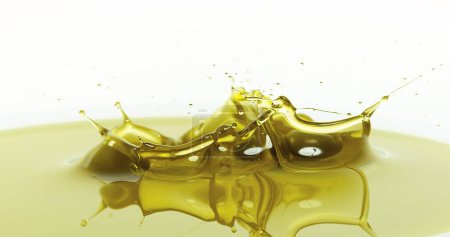 Foto de Aceitunas cayendo en aceite de oliva contra fondo blanco - Imagen libre de derechos