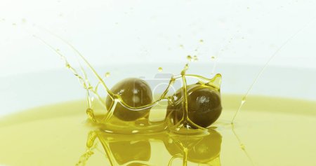 Téléchargez les photos : Olives tombant dans l'huile d'olive sur fond blanc - en image libre de droit