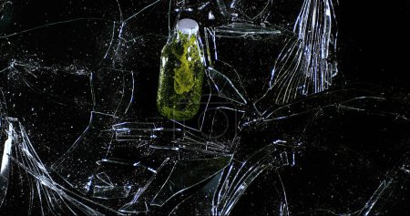 Foto de Botella de cerveza rompiendo el cristal contra fondo negro, - Imagen libre de derechos