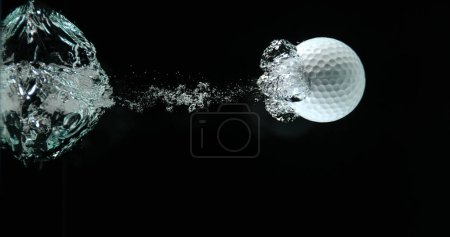 Photo for Golf's Ball Falling into Water against Black background - Royalty Free Image