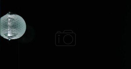 Photo for Golf's Ball Falling into Water against Black background - Royalty Free Image