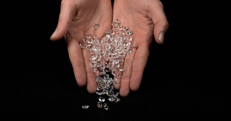 Téléchargez les photos : Main de femme avec diamants sur fond noir - en image libre de droit
