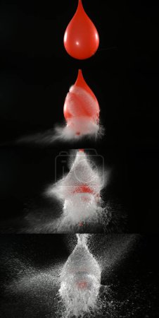 Foto de Disparo rompiendo el globo rojo lleno de agua - Imagen libre de derechos