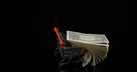Photo for Dollar Coins in Trolley rolling against Black Background - Royalty Free Image
