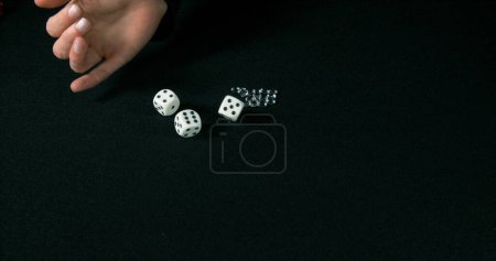 Téléchargez les photos : Main de femme lancer des dés avec des diamants sur fond noir - en image libre de droit