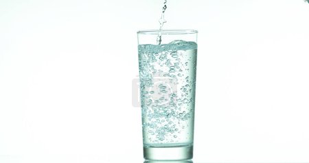 Photo for Water being poured into Glass against White Background - Royalty Free Image