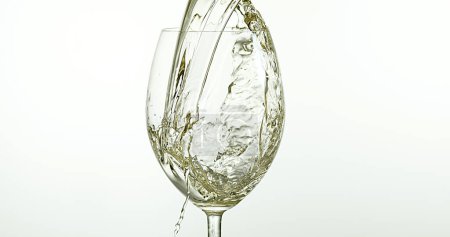 Photo for White Wine being poured into Glass, against White Background - Royalty Free Image